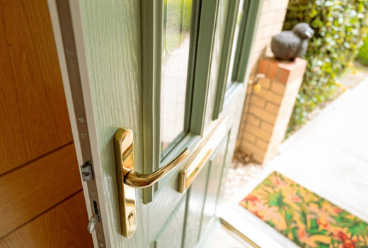green front door opening into hallway with gold handle